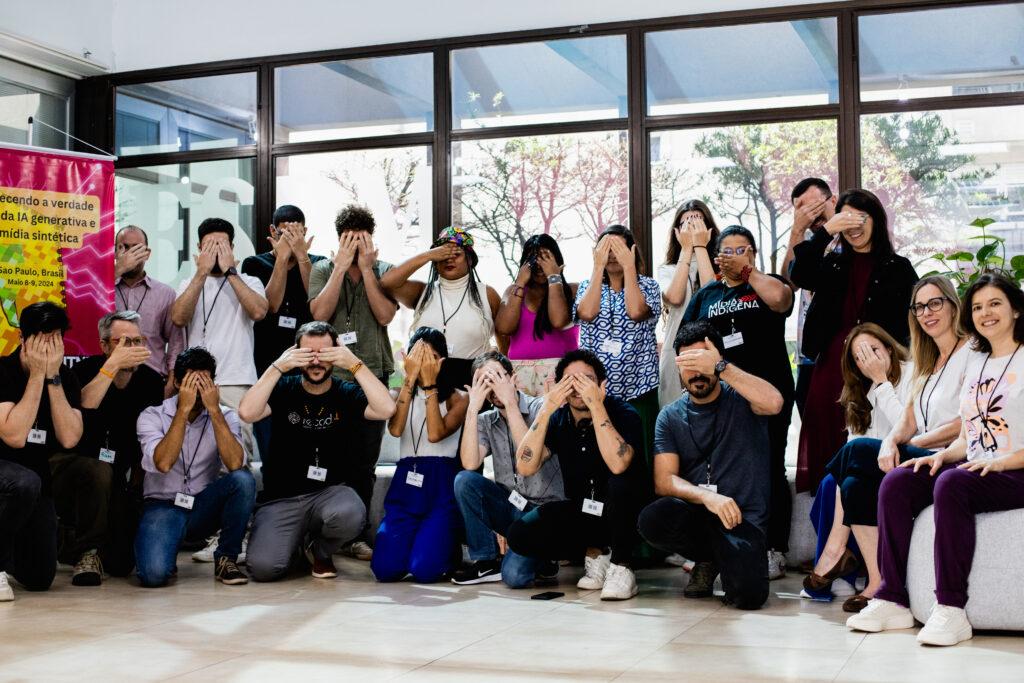 Participants from Brazil workshop pose for a picture covering their faces